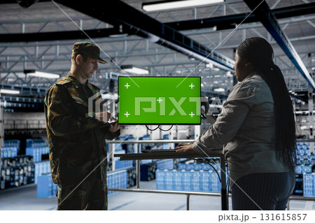 IT specialist briefing commander in army server hub using isolated screen monitor. Military officer in data center and engineer monitoring warfare drone telemetry using chroma key display IT specialist briefing commander in army server hub using isolated screen monitor. Military officer in data center and engineer monitoring warfare drone telemetry using chroma key display 131615857