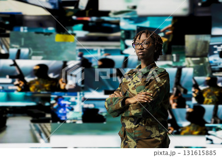 Portrait of soldier in command center housing missile defense system in front of multimedia backdrop. Woman in armed forces headquarters used for tracking rockets using radar systems Portrait of soldier in command center housing missile defense system in front of multimedia backdrop. Woman in armed forces headquarters used for tracking rockets using radar systems 131615885