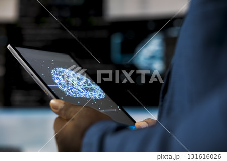 Young professional engineer focused on coding with tablet at an innovation hub, using programming language on terminal window for automation. Tech career in data science. Close up. 131616026