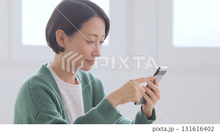 スマホを見るニットの女性 スマホを見るニットの女性 131616402