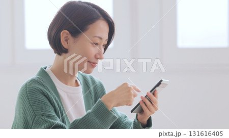 スマホを見るニットの女性 スマホを見るニットの女性 131616405