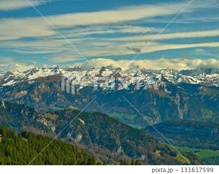 Mountain range showcasing snow-capped peaks and lush valleys under a clear blue sky in Switzerland during daytime 131617599