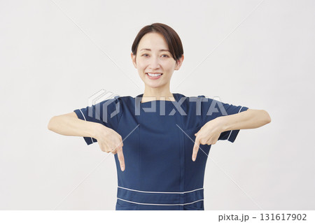 女性　美容看護師　下を指差す　白背景 131617902