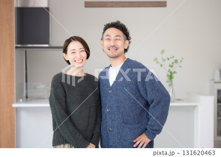 明るいリビングでリラックスする40代の夫婦カメラ目線　自宅の新築やライフスタイル　秋冬 131620463