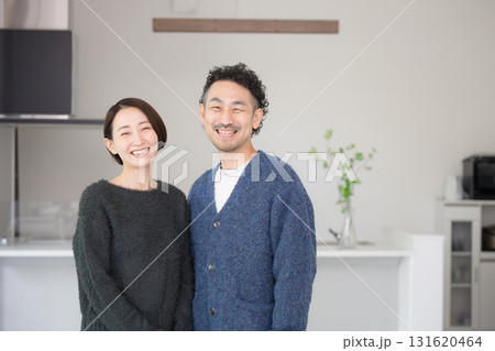 明るいリビングでリラックスする40代の夫婦カメラ目線　自宅の新築やライフスタイル　秋冬 131620464