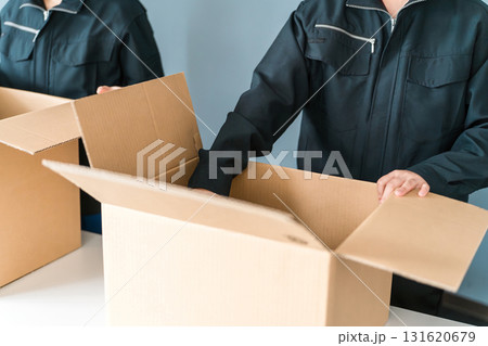 ダンボールに箱詰めする運送・物流・宅急便・宅配便・流通・配達・宅配業者の作業員の手元 ダンボールに箱詰めする運送・物流・宅急便・宅配便・流通・配達・宅配業者の作業員の手元 131620679