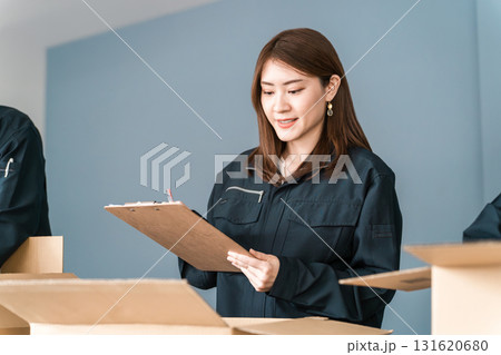 ダンボールに箱詰めする運送・物流・宅急便・宅配便・流通・配達・宅配業者の作業員の女性 131620680