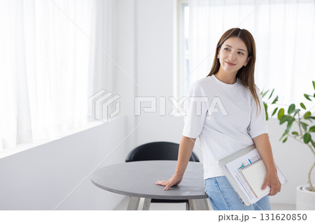 ノートパソコンと書類を持ち微笑む女性 ノートパソコンと書類を持ち微笑む女性 131620850