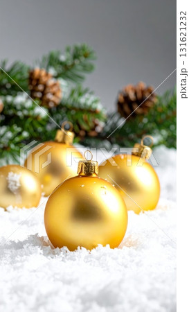 Shiny gold Christmas bauble decoration on a snowy branch of a fir tree for the winter holiday celebration 131621232