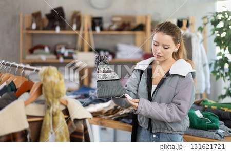 Young woman near showcase examine goods, hat. 131621721