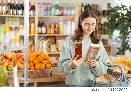 Teenage girl choosing nougat in grocery store 131622035
