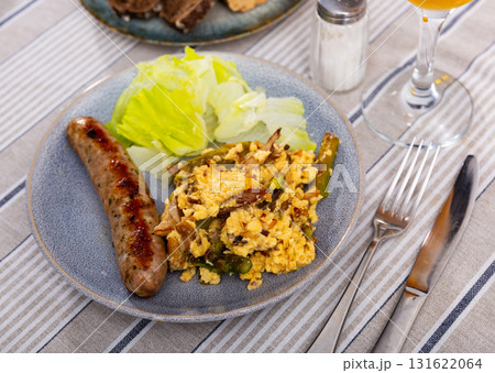 Scrambled eggs with wild mushrooms and champignons with sausages Scrambled eggs with wild mushrooms and champignons with sausages 131622064