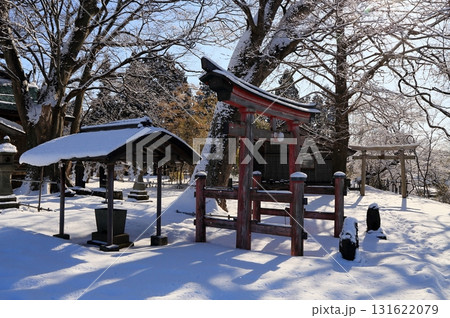 雪の神社赤い鳥居と手水舎 131622079