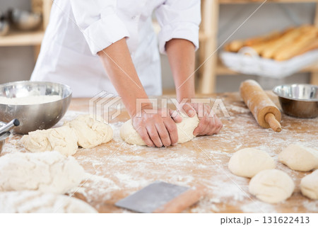 Baker kneading dough on a flour-dusted countertop Baker kneading dough on a flour-dusted countertop 131622413