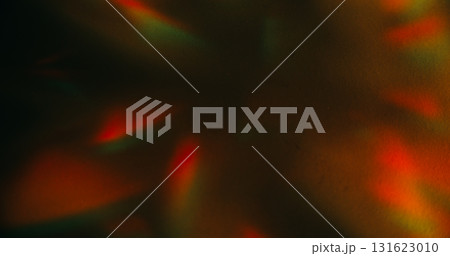 Crystal leak. Blur color background. Orange green rainbow glare shadow gleam reflection on warm art illuminated dark black abstraction. Crystal leak. Blur color background. Orange green rainbow glare shadow gleam reflection on warm art illuminated dark black abstraction. 131623010
