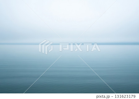 Serene view of calm waters under soft gray skies at dusk Serene view of calm waters under soft gray skies at dusk 131623179