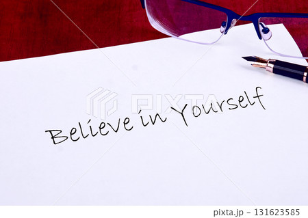 The words Believe in Yourself are hand-written on bright white paper Near the sentiment sits a fountain pen and a pair of spectacles, ready to forge ahead The words Believe in Yourself are hand-written on bright white paper Near the sentiment sits a fountain pen and a pair of spectacles, ready to forge ahead 131623585