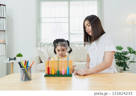 Child Learning with Abacus in Bright Room, Engaging Activities for Cognitive Development, Educator Assisting Young Learner at Home 131624235