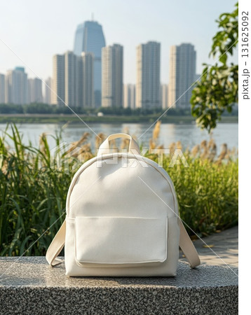 Cream Backpack On Stone With City River And Lush Green Background In Daylight 131625092