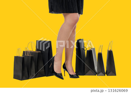 High-heeled legs next to black shopping bags High-heeled legs next to black shopping bags 131626069