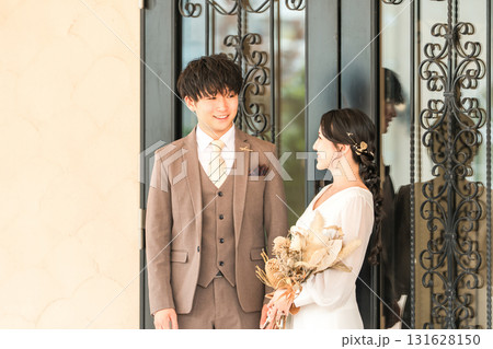 結婚式場の披露宴会場のドアの前にいる新郎新婦 結婚式場の披露宴会場のドアの前にいる新郎新婦 131628150
