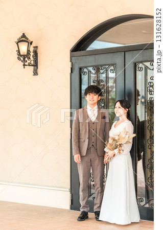 結婚式場の披露宴会場のドアの前にいる新郎新婦 131628152