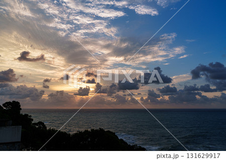南紀勝浦熊野灘の夜明け　黄金色に輝く上空の雲と水平線上の暗雲 131629917