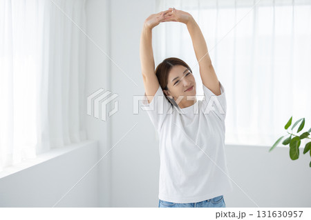 明るい室内でストレッチをする若い女性 131630957