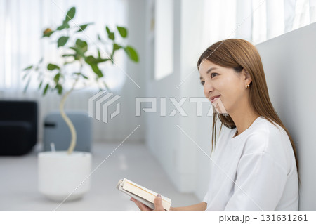 明るい室内で床に座って読書を楽しむ若い女性 明るい室内で床に座って読書を楽しむ若い女性 131631261