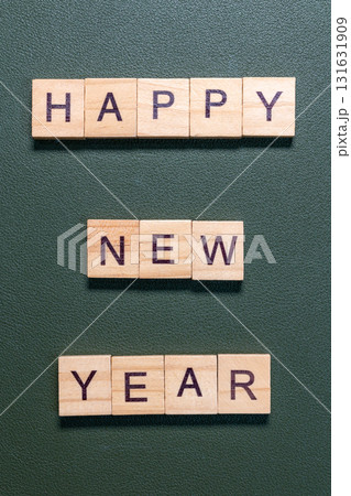 Wooden letter tiles spelling Happy New Year arranged neatly on a textured green background Wooden letter tiles spelling Happy New Year arranged neatly on a textured green background 131631909