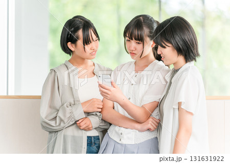 スマホを見ながら不機嫌そうにする私服姿の小学生,中学生の女の子(不満,ストレス,ため息) スマホを見ながら不機嫌そうにする私服姿の小学生,中学生の女の子(不満,ストレス,ため息) 131631922