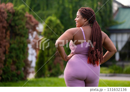 Cute african american young woman in pink sportswear looking happy 131632136