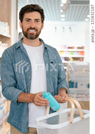 Male taking medicine from shelves in pharmacy 131632187