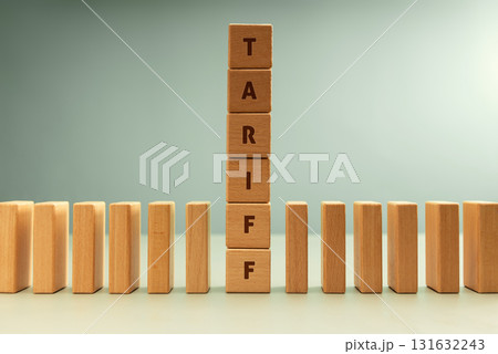 Dominoes row with vertical stack labeled TARIFF, Trade barriers affect global economies in domino impact Dominoes row with vertical stack labeled TARIFF, Trade barriers affect global economies in domino impact 131632243