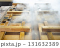 温泉蒸しの湯気が立ち上がる釜がたくさん並ぶ様子 131632389