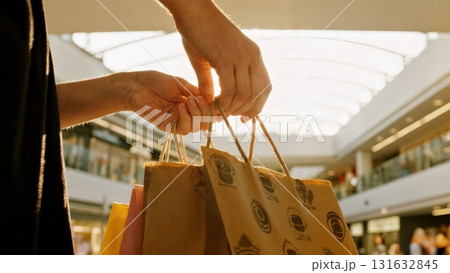 A person's hands holding a shopping bag. Shopping, retail, purchase, consumerism, lifestyle A person's hands holding a shopping bag. Shopping, retail, purchase, consumerism, lifestyle 131632845