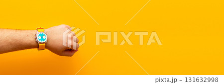 A striking ad banner showcasing a man hand wearing a stylish watch, set against a bold, energetic yellow background. time management ad creative yellow 131632998