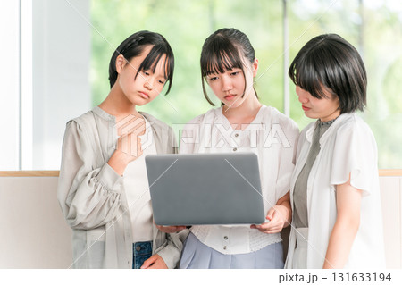 パソコンを見ながら不機嫌そうにする私服姿の小学生,中学生の女の子(不満,ストレス,ため息) パソコンを見ながら不機嫌そうにする私服姿の小学生,中学生の女の子(不満,ストレス,ため息) 131633194