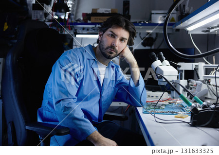 Dedicated and focused engineer working in a laboratory setting on advancements in electronics Dedicated and focused engineer working in a laboratory setting on advancements in electronics 131633325