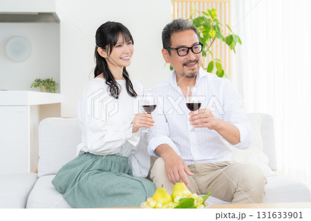 リビングでワインを飲むミドルの夫婦 リビングでワインを飲むミドルの夫婦 131633901