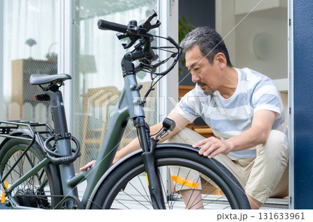 庭で電動自転車をメンテナンスをするミドル男性 131633961