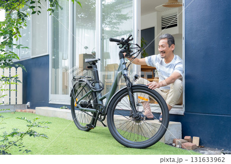 庭で電動自転車をメンテナンスをするミドル男性 131633962