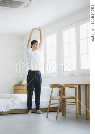 ベッドルームで伸びをする男性 131634505