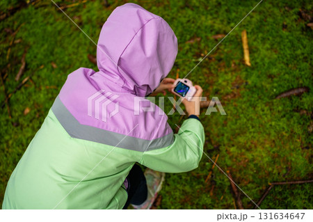 Little girl documenting forest environment with a toy camera during outdoor exploration in Czech woodland. Early childhood education, nature study and environmental awareness through play. Little girl documenting forest environment with a toy camera during outdoor exploration in Czech woodland. Early childhood education, nature study and environmental awareness through play. 131634647