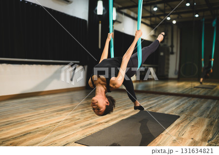 Young woman focusing on strength, balance, and flexibility in a modern yoga studio Young woman focusing on strength, balance, and flexibility in a modern yoga studio 131634821