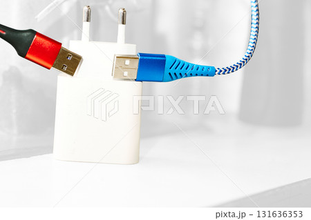 Two red blue usb cables,charger on white Two red blue usb cables,charger on white 131636353