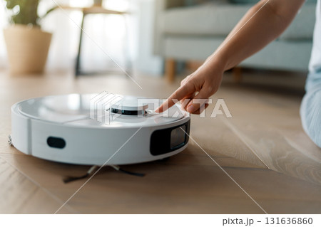 White robotic vacuum cleaner on wooden floor White robotic vacuum cleaner on wooden floor 131636860