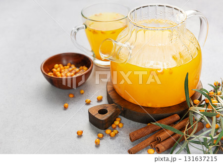 Sea buckthorn tea with cinnamon in a glass teapot 131637215