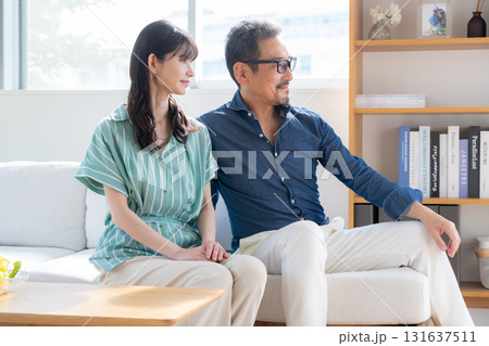 リビングでくつろぐミドルの夫婦 131637511