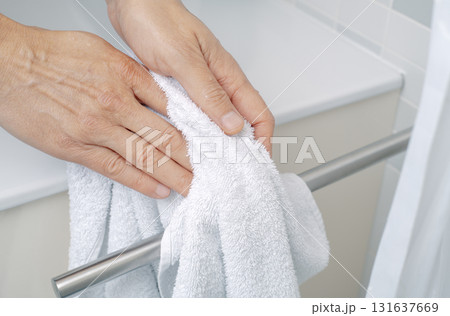 a man drying hands with a towel in a bathroom a man drying hands with a towel in a bathroom 131637669
